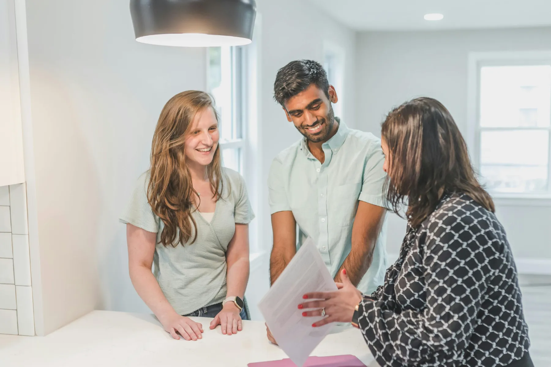 Tenants and agent discussing rental documents, understanding if subletting is legal in Dubai before signing a lease.